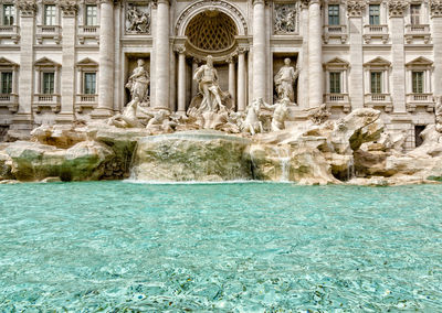 View of fountain in front of historical building