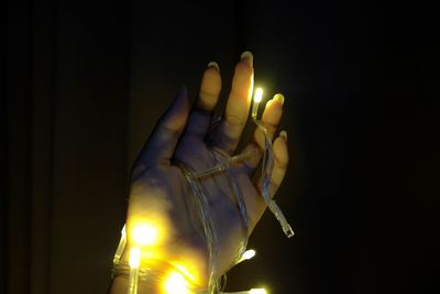 Close-up of hand holding illuminated lighting equipment