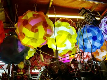 Close-up of multi colored balloons hanging at night