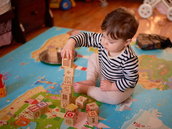 Cute toddler boy makiung a tower from wood blocks