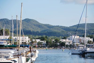 Sailboats moored in sea against sky