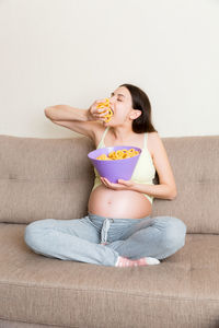 Pregnant woman is eating chips because of salt cravings. unhealthy junk food during pregnancy.