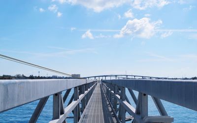 Footbridge over river against sky