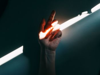 Close-up of hand with sunlight falling on wall