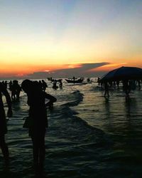 Silhouette of people walking on beach