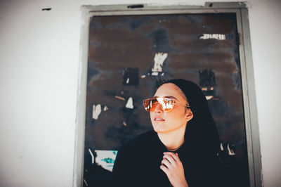 Portrait of young woman looking through window