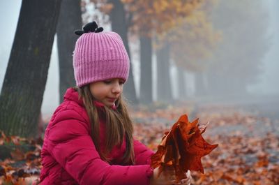 Girl holding autumn leaves