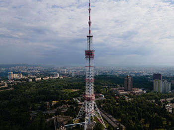 Aerial view of buildings in city against cloudy sky