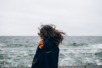 Portrait of happy smiling woman walking outdoor in the sea shore beach on wind weather