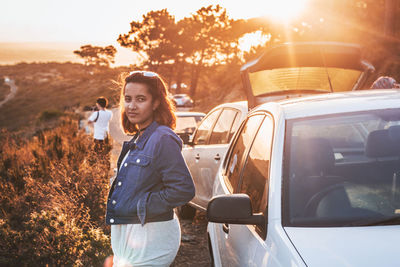 Portrait of woman standing by car