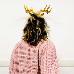 Rear view of woman standing against wall