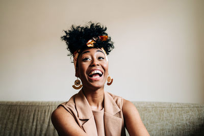 Portrait of smiling young woman against wall