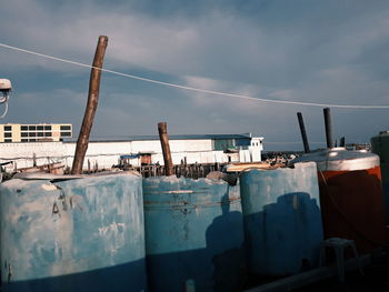 Boats moored at harbor against sky