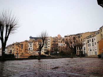 Houses by river against clear sky