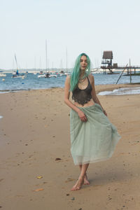 Full length portrait of young woman on beach