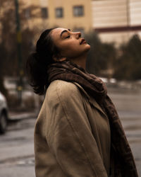 Side view of young woman standing outdoors