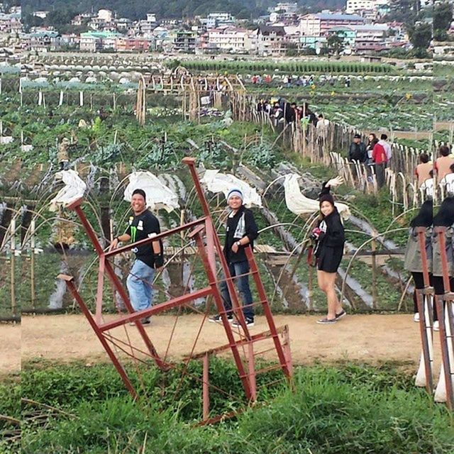 lifestyles, leisure activity, grass, men, person, casual clothing, togetherness, large group of people, field, sitting, full length, park - man made space, childhood, playing, playground, green color, bonding, enjoyment