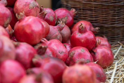 Harvest of ripe pomegranate on dry straw at outdoor farmer market in turkey. vegetarian healthy food