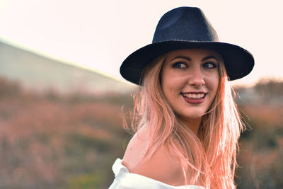 Portrait of smiling young woman wearing hat