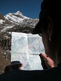 Rear view of woman photographing against mountain range