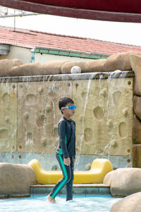 Boy wading in swimming pool at water park