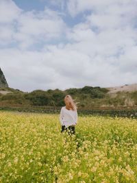 Woman with blond long hair standing in a field