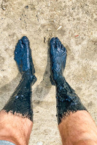 Low section of person standing on sand