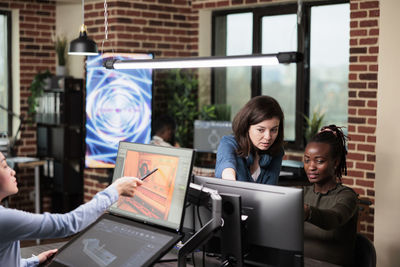 Portrait of young woman using digital tablet in office