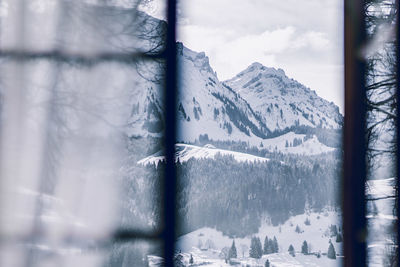 Scenic view of snowcapped mountains seen through window