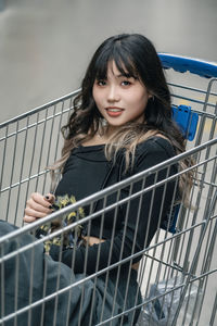 Portrait of smiling young woman sitting in shopping mall