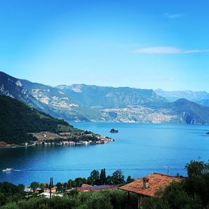 Scenic view of lake and mountains against blue sky