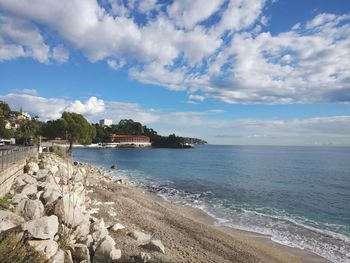 Scenic view of beach against cloudy sky