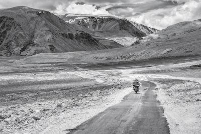 Scenic view of road against snowcapped mountains