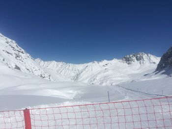 Scenic view of snowcapped mountains against clear blue sky