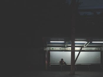 Rear view of woman standing in illuminated building