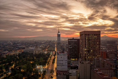 Buildings in city against cloudy sky