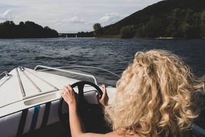 Woman in boat on lake against sky