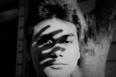 Close-up portrait of young man standing against wall