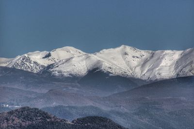 Scenic view of snowcapped mountains against clear blue sky