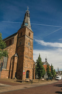 Clock tower amidst buildings in city against sky