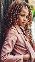 Portrait of girl with curly brown hair standing outdoors