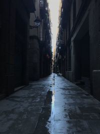 Empty road amidst buildings in city during rainy season