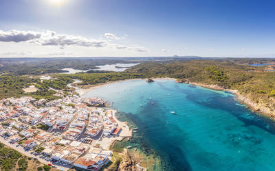 Spain, balearic islands, menorca, aerial view of bay in front of coastal village in summer
