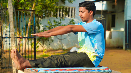 Athletic rajasthani man in a sporty uniform engaged in yoga at outdoor. yoga instructor, in outdoor