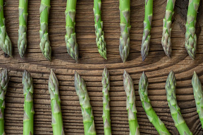Raw garden asparagus stems. fresh green spring vegetables on wooden background. 