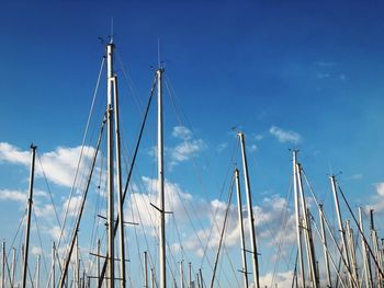 Low angle view of sail masts in blue sky