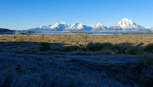 Scenic view of snowcapped mountains against clear blue sky