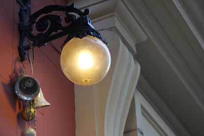 Low angle view of illuminated light mounted on building