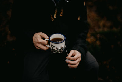 Man holding an enamel mug of tea