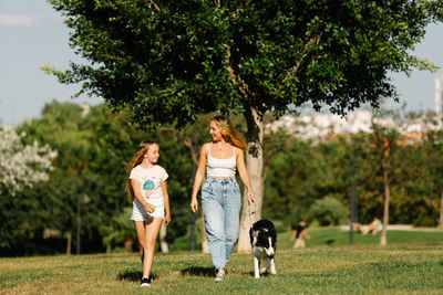 Woman with dog on plant against trees